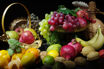 Grapes in a vase and fruits on the table. 
