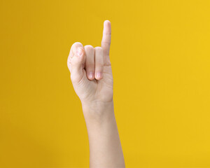 Naklejka premium Partial image of person showing one little finger gesture on yellow background
