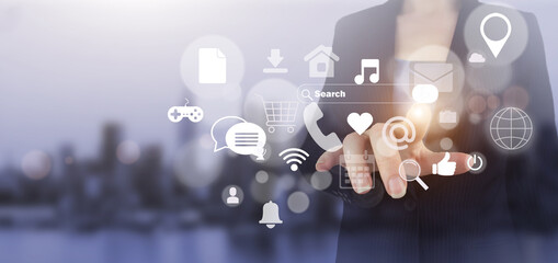 Social media or social network notification. Hand touch digital screen hologram social media icons sign on city light blurred background. Communication and network concept.