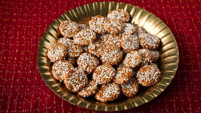 Revdi revri til gud revdi rewari sesame cookie woman hand serving winter food Indian festival food snack sweet Lohri Makar Sankranti Pongal Diwali 4K video footage harvest Tamil Nadu  Punjab India.