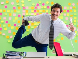 Man in the office with many conflicting priorities doing exercis
