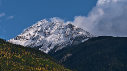 Beautiful view of rugged snow-capped mountain viewed from Robson Valley near McBride, British Columbia, Canada in autumn season with colorful forest.