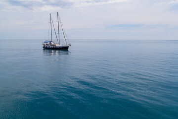 Fototapeta premium Sailboat sailing in the morning with blue cloudy sky. Luxury yacht in open waters with beautiful clouds
