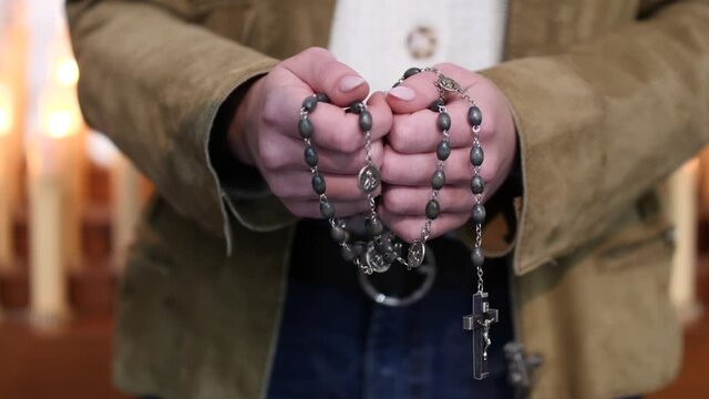 Mani piegate in preghiera, tenendo i grani del rosario con crocifisso.
Primo piano delle mani giunte in preghiera per misericordia e perdono, mostrando fede, devozione e speranza.