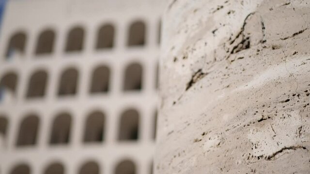Mano che accarezza colonna antica di marmo travertino. Arte e monumenti. sullo sfondo il colosseo Quadrato a Roma.
Immagine evocativa di arte e bellezza.