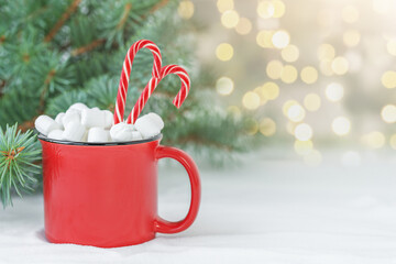 Christmas backdrop with a Christmas drink with marshmallows and candy canes
