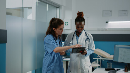 Doctor and nurse working with tablet for healthcare system in cabinet. Medical team of medic and...