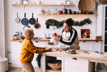 two boys  in the kitchen are cooking