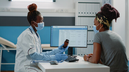Specialist holding bottle of pills to cure patient with disease at checkup. Doctor giving flask...