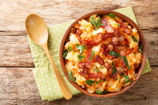 Hutspot Dutch carrot potato mash with bacon close up in the bowl on the table. Horizontal top view from above