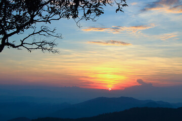 Fototapeta na wymiar beautiful sunset with mountain view and tree silhouette