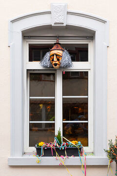 Basel, Switzerland - February 21. Carnival window decoration with a mask and colorful garlands