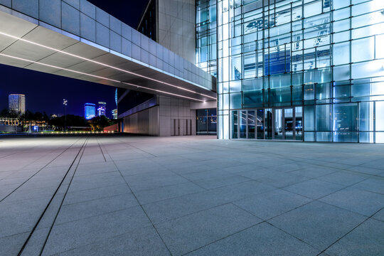 Empty square floor and modern commercial office building at night