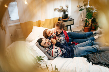 Happy family have fun on bed. Home.