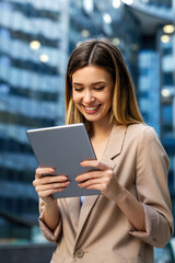 Fototapeta premium Portrait of successful woman using digital tablet in urban background. Business people concept