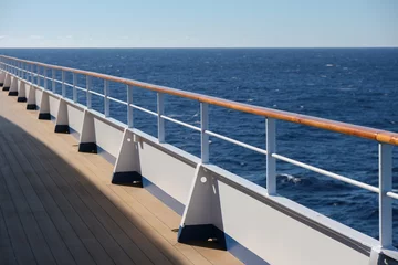 Deurstickers White luxury cruiseship cruise ship liner Silver Shadow on blue sea with panoramic seascape ocean views from deck on sunny blue sky day with parts of deck and railing © Tamme