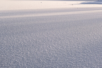 Texture of ice of frozen lake in sunlight