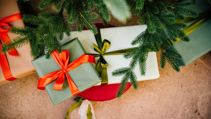 a boxes with red and green ribbon under the christmas tree