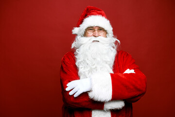 Fototapeta na wymiar Portrait of smiling caucasian Santa Claus on red background