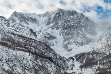 Obraz premium European Alps in winter. Monte Rosa from Macugnaga, north Italy, with the impressive east wall covered with ice and, at the base, one of the two ski areas. Winter background 