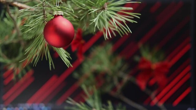 Shot of christmas tree decorations with a background of red diagonal lines. Smooth motion camera.