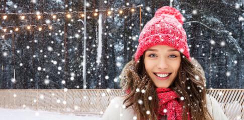 winter holidays, christmas and leisure concept - portrait of happy smiling teenage girl or young woman over skating rink on background