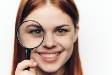 pretty woman grimacing with magnifying glass near face close-up