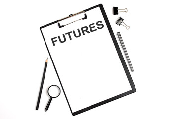 On a white background magnifier, a pen and a sheet of paper with the text FUTURES . Business concept
