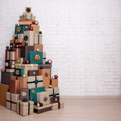 Christmas gift boxes laid out in the shape of a Christmas tree and copy space over white brick wall