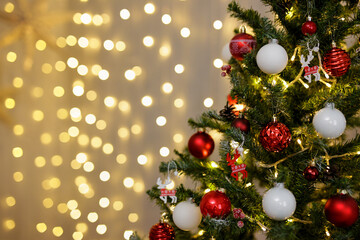 close up of decorated Christmas tree with colorful baubles and copy space over festive led lights