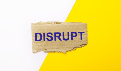 On a white and yellow background, brown torn cardboard with the text DISRUPT