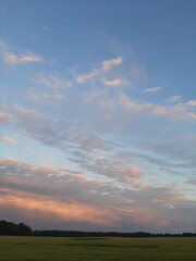 Naklejka na ściany i meble Beautiful summer sunset. Sunset over the field. Beautiful sunset sky. Beautiful clouds in the sky.