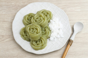 Kue Lumpang Pandan or Kue IJo, Indonesian traditional food with springy texture, made from sago flour and rice flour, sugar and pandan. Served in white plate, selective focus image.

