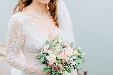 Beautiful bride is holding a bridal bouquet with eucalyptus and roses. Modern wedding. Bridal bouquet 