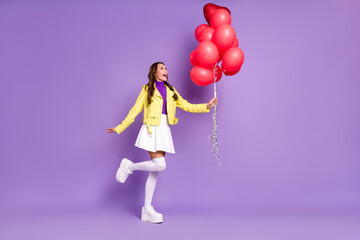 Full size profile side photo of young excited lady hold many balls decoration event isolated over purple color background