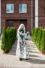 Portrait of young blonde woman posing in autumn street