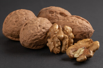 Walnuts scattered on a dark background, macro