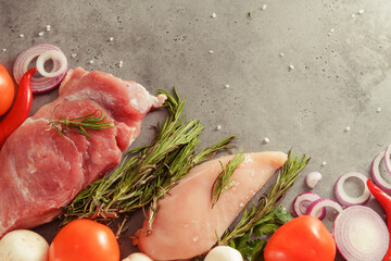 raw chicken fillet with rosemary,  pork tenderloin, mushrooms, tomato, chili pepper,  onion,   top view on a gray