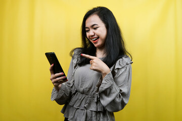 Naklejka premium Beautiful young woman with hands holding smartphone, promoting product, presenting something, advertisement, isolated