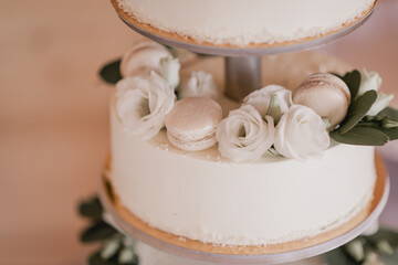 Beautiful and delicious white wedding cake with macaroons