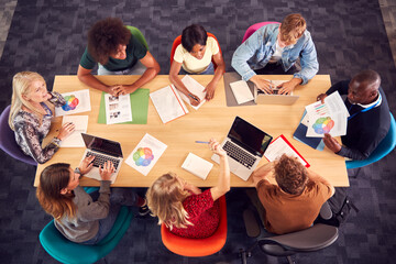 Overhead Shot Of University Or College Students Sitting Around Table With Tutors In Lesson
