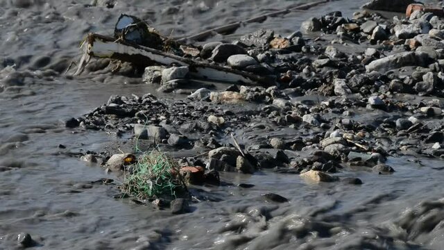 river of mud and water rushes towards the sea after intersting rains