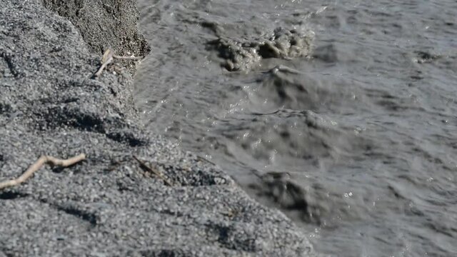 river of mud and water rushes towards the sea after intersting rains
