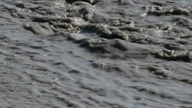 river of mud and water rushes towards the sea after intersting rains