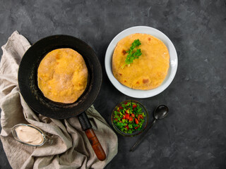 Homemade corn flatbread on frying pan cilantro green tomato salsa linen cloth. Handmade mexican tortilla vegetable. Traditional Indian Makki ki roti bread top view. Wheat flour dough authentic cuisine