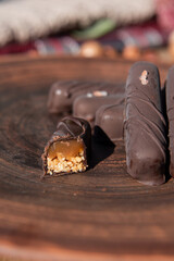 Chocolate with caramel and nuts. Copy space. Close-up. Soft focus background.