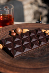 Chocolate with almond on brown dish. Close-up. Copy space. 