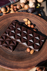Chocolate with almond on brown dish. Close-up. Copy space. 