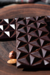 Chocolate with almond on brown dish. Close-up. Copy space. 