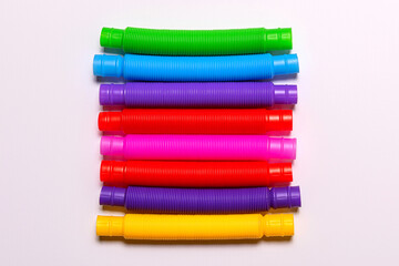 Row of bright new straight pop tubes on white paper background